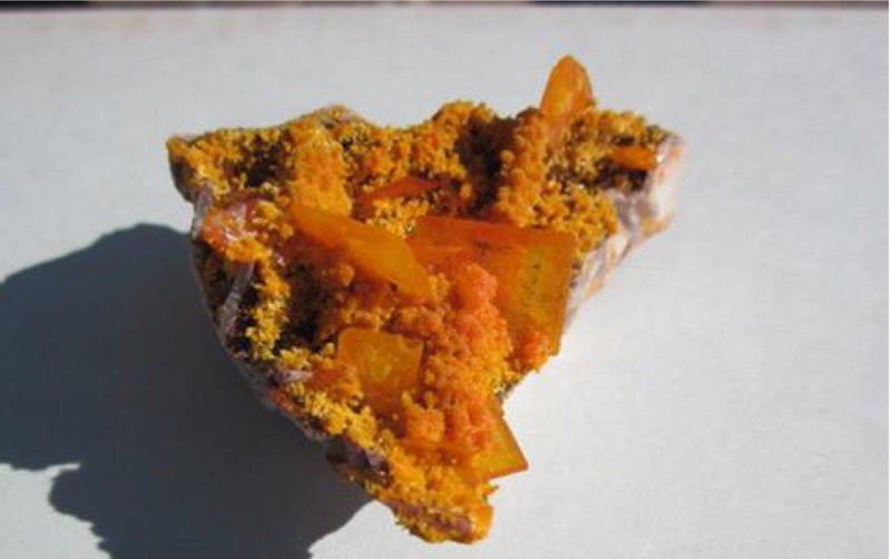 Bright orange mineral crystals on a rough rock.